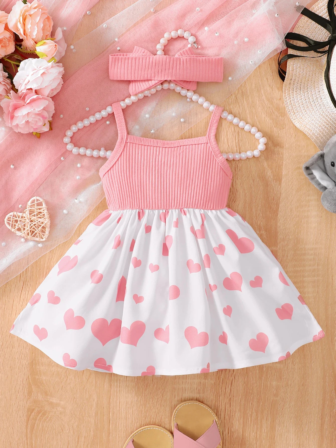 Abito estivo alla moda per bambina con grazioso cuoricino e bretelle a forma di elefantino dei cartoni animati.