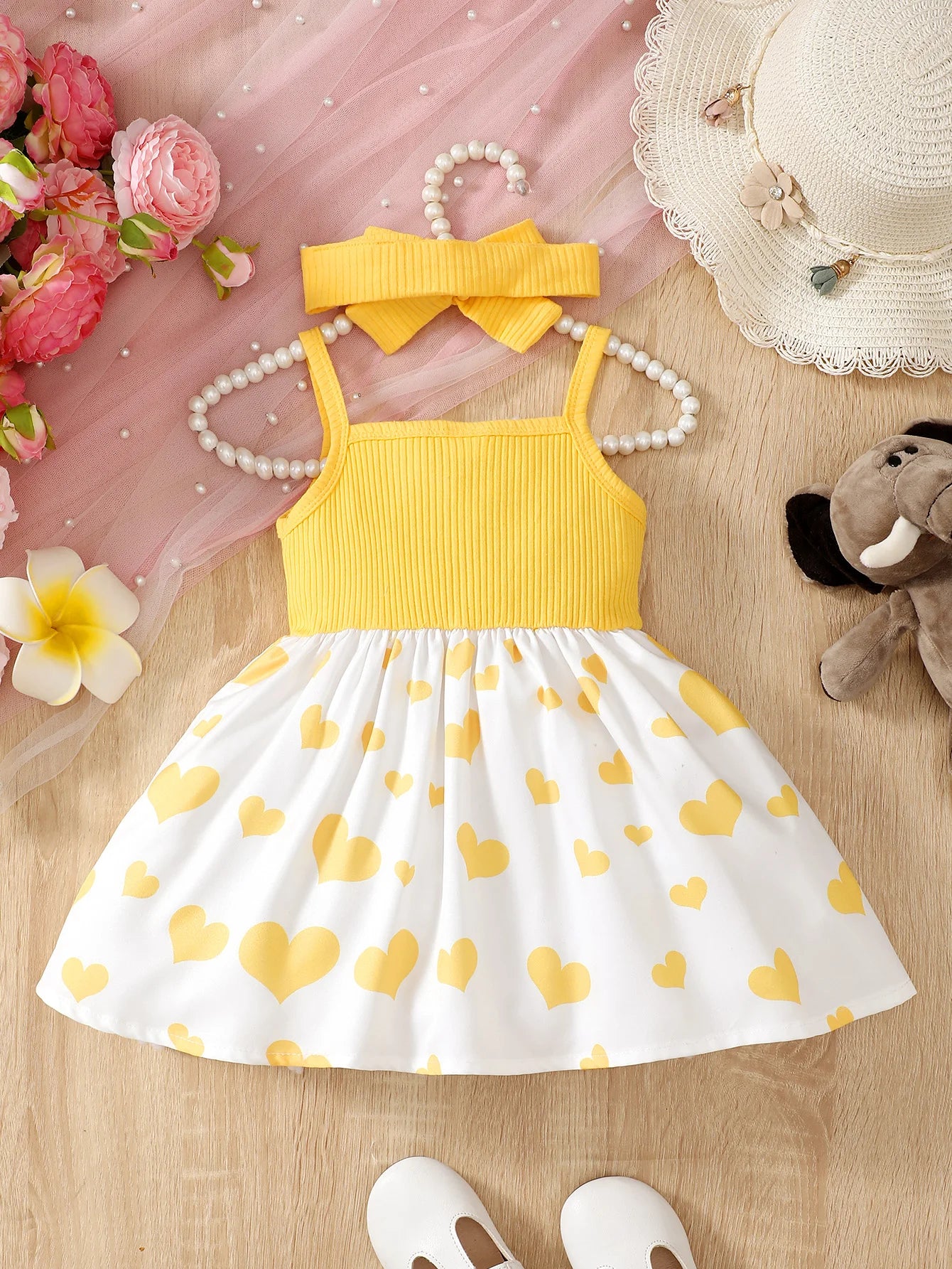 Abito estivo alla moda per bambina con grazioso cuoricino e bretelle a forma di elefantino dei cartoni animati.