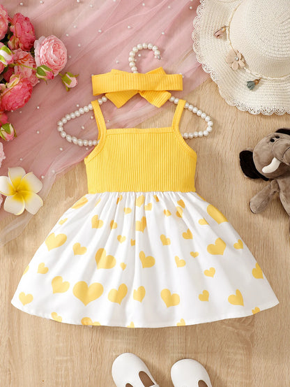 Abito estivo alla moda per bambina con grazioso cuoricino e bretelle a forma di elefantino dei cartoni animati.