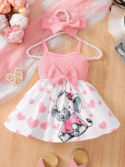 Abito estivo alla moda per bambina con grazioso cuoricino e bretelle a forma di elefantino dei cartoni animati.