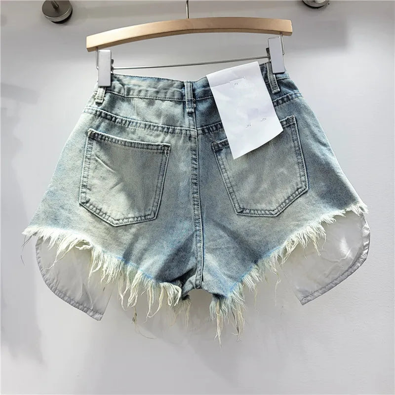 Nuova collezione estate 2026: pantaloncini in denim rosa con fori, vita alta, modello snellente, linea ad A, orlo sfrangiato.