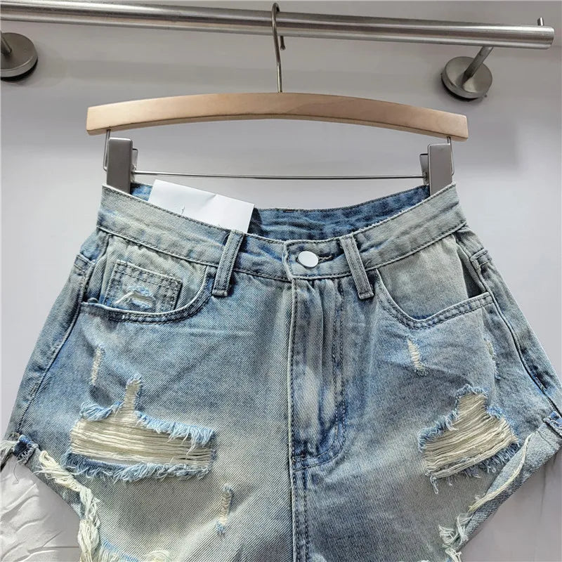 Nuova collezione estate 2026: pantaloncini in denim rosa con fori, vita alta, modello snellente, linea ad A, orlo sfrangiato.