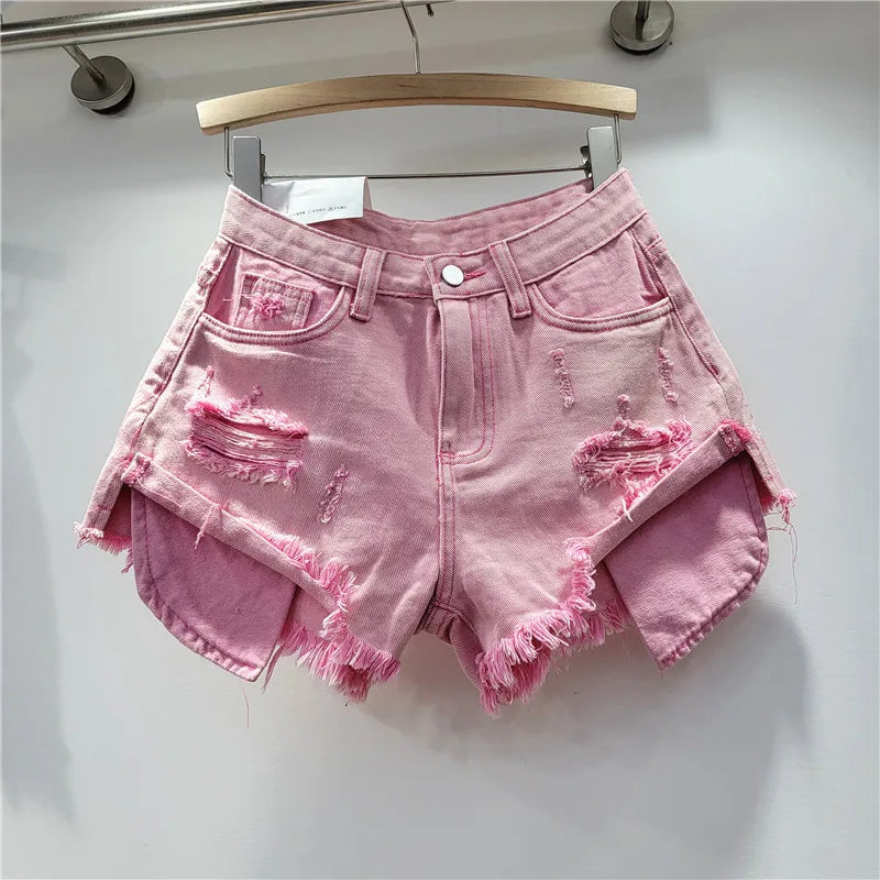 Nuova collezione estate 2026: pantaloncini in denim rosa con fori, vita alta, modello snellente, linea ad A, orlo sfrangiato.