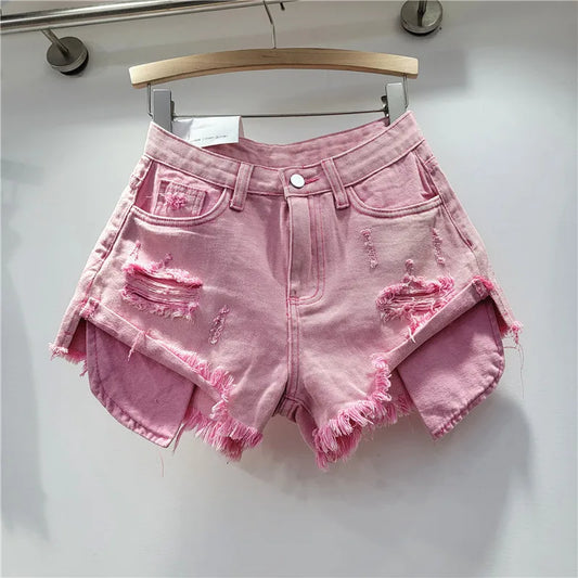 Nuova collezione estate 2026: pantaloncini in denim rosa con fori, vita alta, modello snellente, linea ad A, orlo sfrangiato.